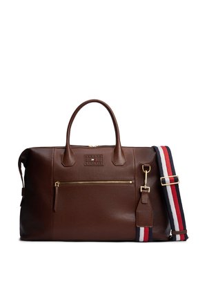 Sac de voyage en cuir marron avec poche avant zippée, double poignée et une bandoulière amovible avec des rayures rouges, blanches et bleues ainsi que des ferrures dorées.