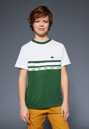 T-shirt vert et blanc à col rond, avec une rayure horizontale verte et une bande de logo jaune. Texture de tissu douce et lisse.