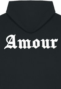 Hoodie noir présentant un grand texte graphique blanc "Amour" au dos dans une police ornée. Le tissu semble doux avec une texture lisse.