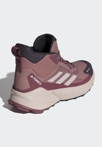 Pusiau aukšti žygio batai mauve ir tamsiai violetiniais atspalviais. Batai turi tinklelio viršutinę dalį, tris baltas juosteles, tekstūruotą pado struktūrą ir paminkštintą apykaklę palaikymui.