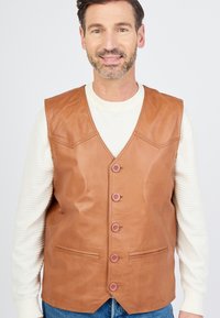 Bruine leren vest met een V-hals ontwerp, zes knopen aan de voorkant en zijzakken. Glad textuur met een strakke pasvorm.