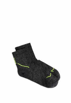 Par de calcetines deportivos tobilleros de color gris oscuro con detalles en amarillo neón, etiquetados como izquierda y derecha, colocados planos sobre fondo blanco.