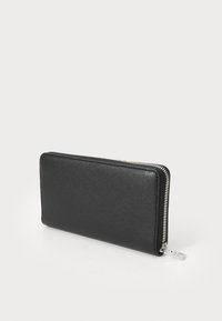 Portefeuille en cuir noir avec une finition texturée, doté d'une fermeture éclair en métal argenté sur le bord et d'une forme rectangulaire fine.