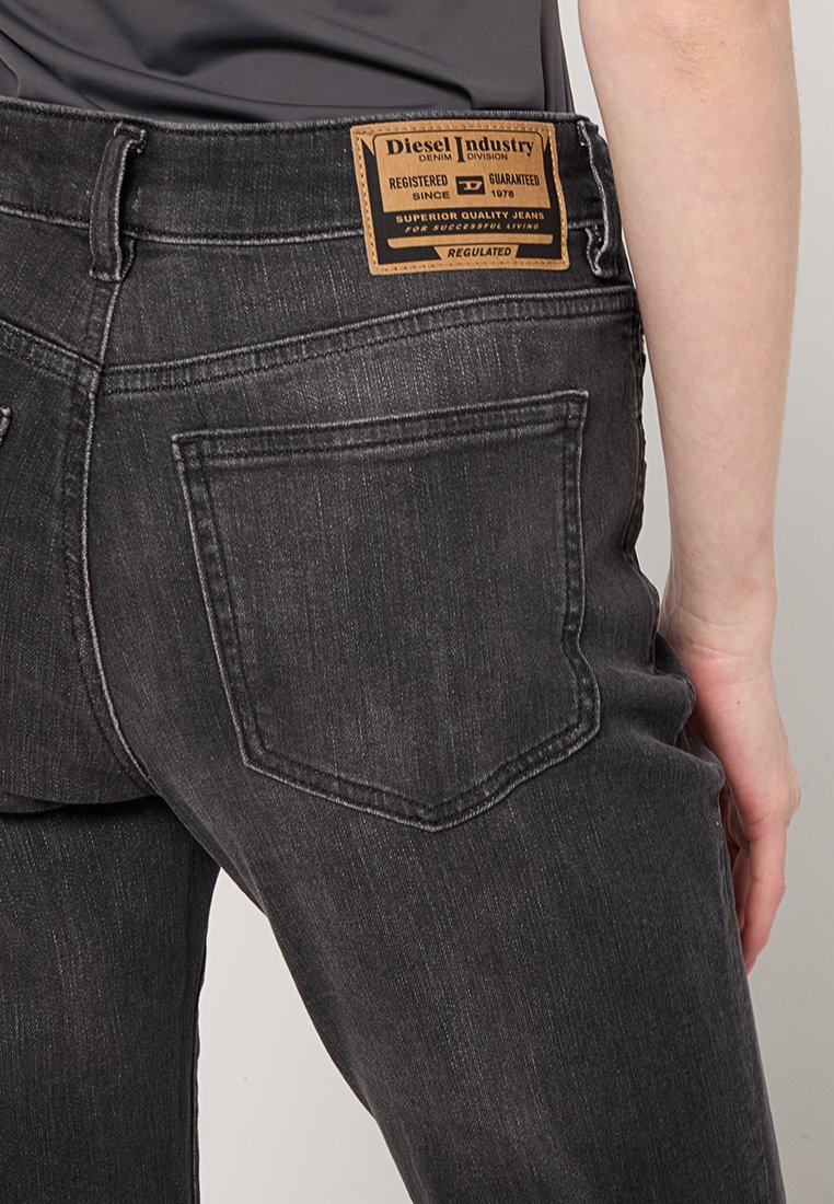 Ciemnoszare dżinsy denimowe z markową skórzaną naszywką na pasku. Posiadają standardowe tylne kieszenie oraz lekko wypłowiały efekt.