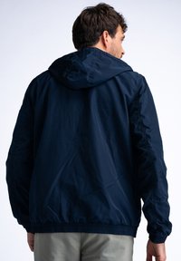 Bordó lehký kabát s kapucí, elastickými manžetami a nařaseným lemem. Vyrobeno z hladkého syntetického materiálu.