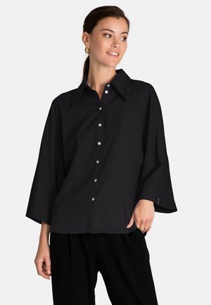 Black oversized button-up shirt with a classic collar, wide sleeves, and light buttons. Smooth fabric with a soft texture.