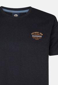 Navy cotton t-shirt with short sleeves, crew neck, and orange print reading "PETROL IND" and additional text below design on the left chest.