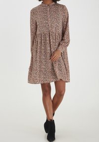 Abito con motivo floreale, maniche lunghe, colletto alto, vita arricciata e una vestibilità comoda. I colori includono rosa, rosso, verde e bianco.