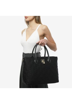 Sac fourre-tout noir matelassé avec un motif hexagonal, doté de poignées en cuir noir et d'une fermeture à verrou en argent brillant. Texture lisse sur l'ensemble.