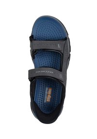 Sandalia de slip-on de Skechers en gris oscuro con correas ajustables, plantilla texturizada azul y parte superior perforada para transpirabilidad. Diseño ligero.