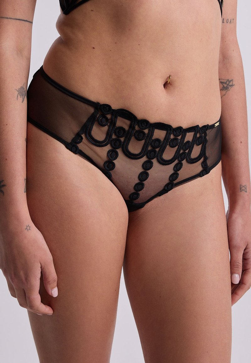 Panties in rete nere con un design di ricamo floreale e accenti circolari lungo la vita. Texture morbida con un aspetto trasparente.