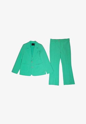 Blazer verde su misura con due tasche frontali e pantaloni a vita alta abbinati con passanti per cintura e chiusura frontale con bottoni.
