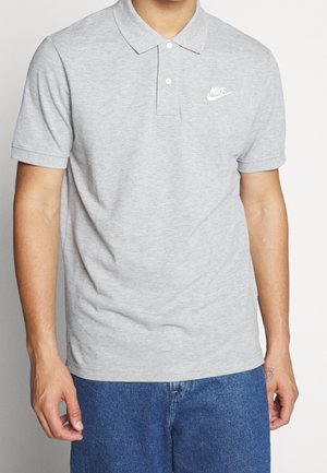 Szara koszulka polo wykonana z mieszanki bawełny. Posiada zapięcie na guziki, krótkie rękawy oraz białe logo Nike na klatce piersiowej.