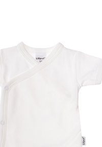 White cotton baby bodysuit with short sleeves, V-neck design, snap closures on the side, and subtle stitching detail. Labels are visible.
