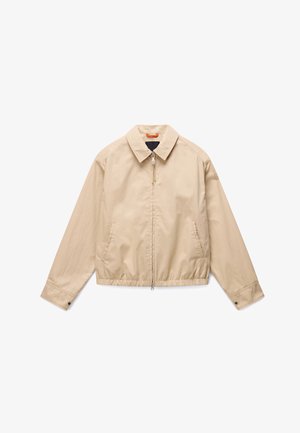 Veste légère beige avec fermeture éclair intégrale à l'avant, col avec col, ceinture élastique, poches latérales et poignets de manches boutonnés.