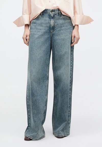 Hellblaue, hoch taillierte Jeans mit weitem Bein aus Denim mit verwaschenem Finish, ausgestattet mit Knopfverschluss und klassischem Fünf-Taschen-Design.