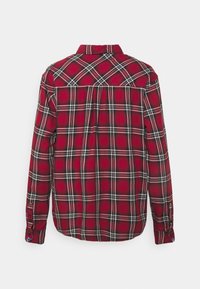 Chemise à manches longues à carreaux rouges et noirs, en tissu coton, col boutonné, détail du dos, poignet ajustable avec fermeture à bouton, vue de dos.