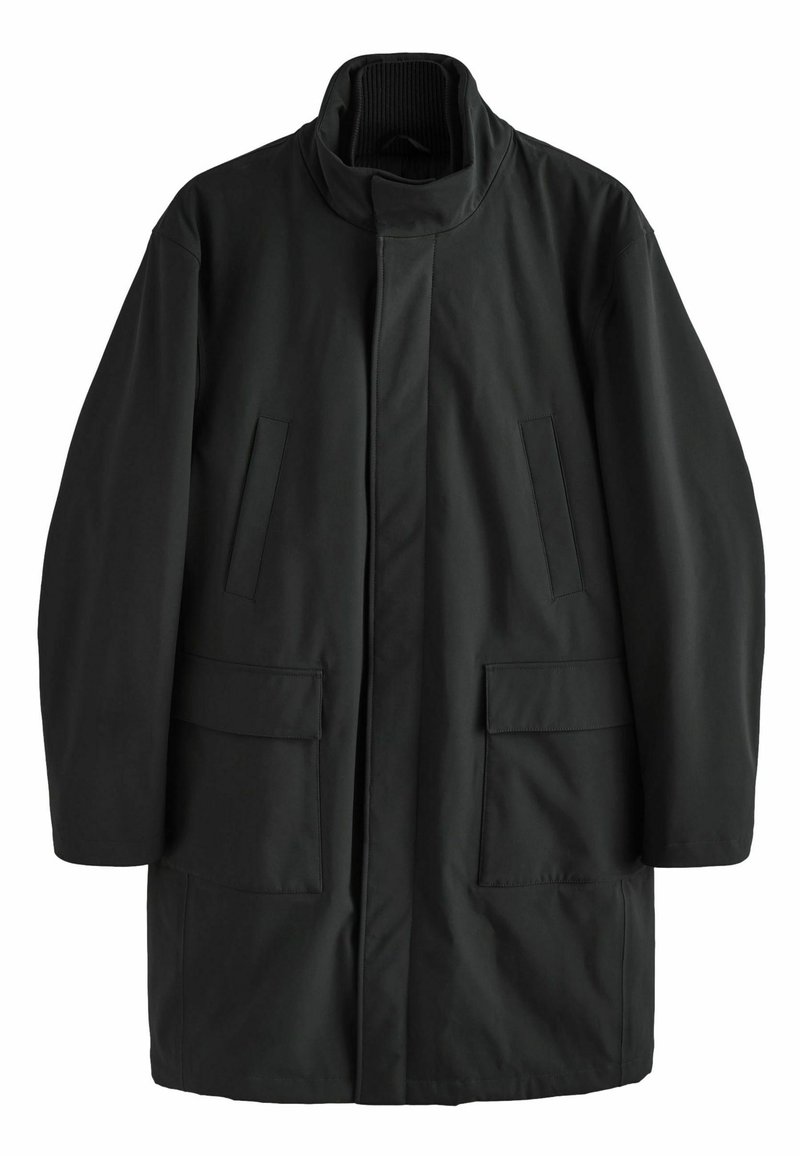 Abrigo negro a la altura de la rodilla con cuello alto, dos bolsillos laterales y dos bolsillos delanteros tipo parche. Tejido exterior liso, diseño minimalista.