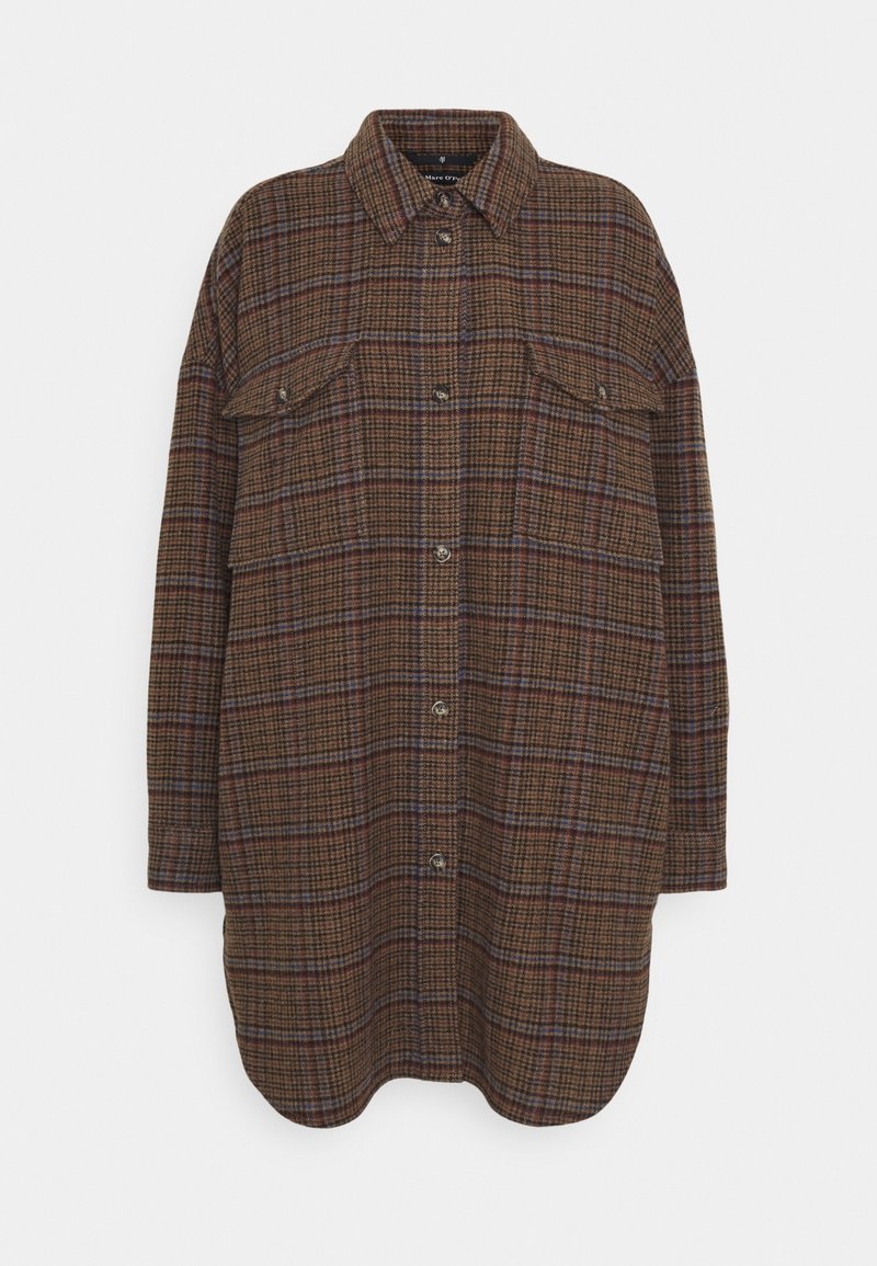 Lange oversized shirtjas in een bruine ruitpatroon met knoopsluiting, twee borstzakken met klep en een puntige kraag op een witte achtergrond.