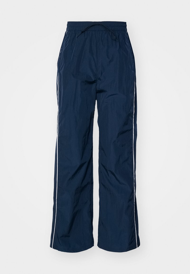 Marineblauwe, lichte en waterdichte broeken met een elastische tailleband, trekkoord en witte zijstrepen. Kenmerkt zich door een losse pasvorm.
