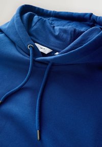 Blaues Baumwollhoodie mit verstellbarem Kapuzenzug, strukturiertem Stoff und einem Etikett mit der Aufschrift "NEXT" im Nacken.