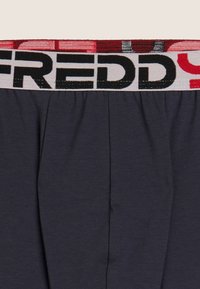 Boxer grigio scuro con una fascia elastica spessa in vita con la scritta a contrasto "FREDDY" in nero e rosso. Materiale in cotone liscio con pieghe.
