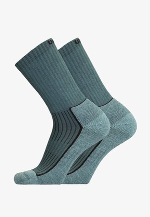 Teal crew socks with ribbed texture, reinforced toe and heel, and black accents near the cuff and toe. Made of soft, durable material.