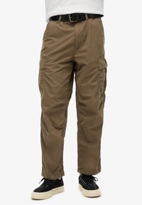 Khaki cargobroek met een elastische tailleband, meerdere zijzakken en een ontspannen pasvorm. Draag met zwarte sneakers en een wit shirt.