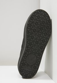 Suola nera della scarpa con un motivo di tread geometrico texturizzato, logo circolare e testo "Victoria Made in Spain" visibile sul fondo.