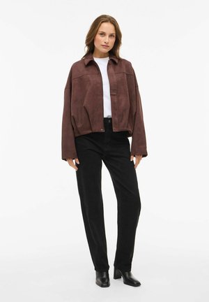 Brown suede cropped jacket with a collared neckline, paired with black corduroy pants and black heeled ankle boots. Plain white T-shirt underneath.
