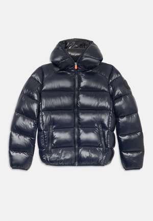 Námornícky modrá nadýchaná bunda s lesklým povrchom, predným zipsom, vysokým golierom a dvoma bočnými vreckami; obsahuje kapucňu a prešívaný dizajn panelov.