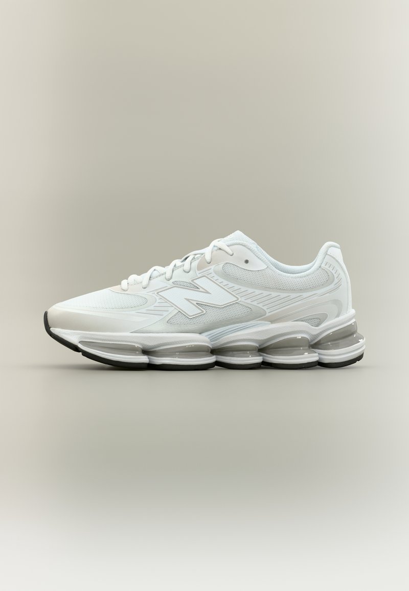 Baskets de sport blanches New Balance avec tige en mesh et synthétique, semelle coussinée distinctive avec plusieurs unités d’air arrondies, logo latéral visible.
