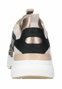 Sportieve sneaker met een zwarte en metallic gouden bovenkant, een gestructureerde afwerking en een robuuste witte zool met een hieltab voor gemakkelijk aan- en uittrekken.