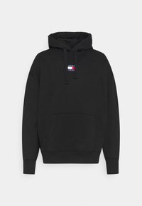 Sudadera negra de tejido suave, con un bolsillo frontal y capucha con cordón. Parche de logo notable en rojo, blanco y azul en el pecho.