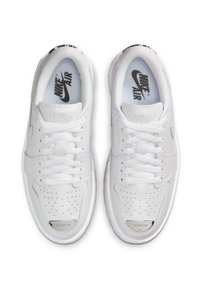 Baltas Nike Air apavi ar gludu ādas augšu, perforētu pirkstu daļu, baltām auklām un metāliski sudraba akcentiem uz papēža.