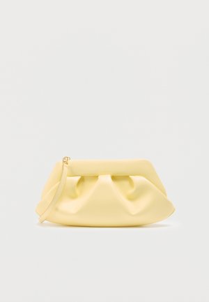 Blød gul læderclutch med foldet detalje og en tynd håndledsrem på en ensfarvet lys baggrund.