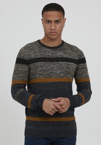 Maglione lavorato a maglia con strisce grigio scuro, grigio chiaro e arancione. Collo rotondo e maniche lunghe con polsini a coste. Tessuto testurizzato.