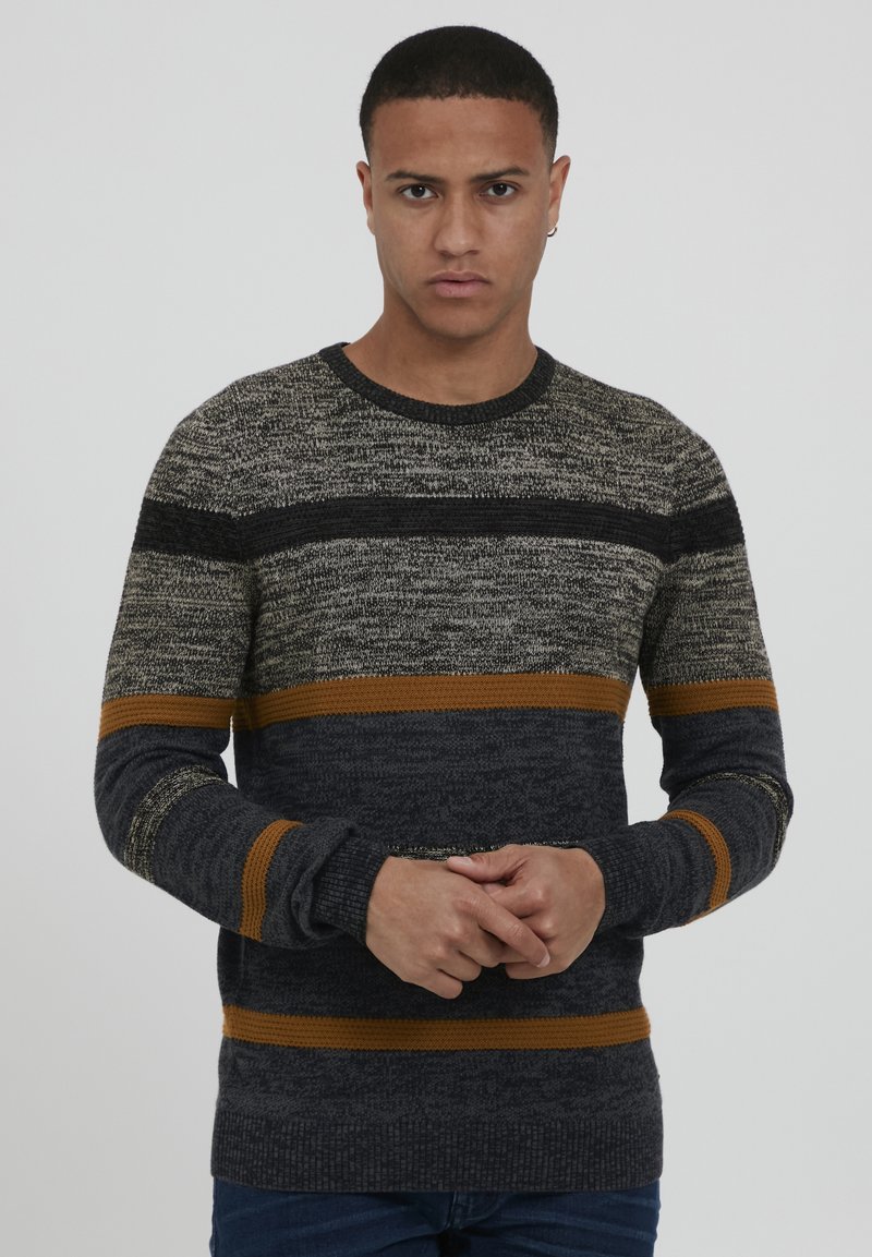 Maglione lavorato a maglia con strisce grigio scuro, grigio chiaro e arancione. Collo rotondo e maniche lunghe con polsini a coste. Tessuto testurizzato.