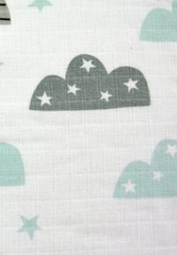 Tela de algodón con nubes gris claro y turquesa y estrellas blancas sobre un fondo blanco texturizado.
