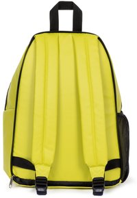 Sac à dos jaune avec une texture lisse, un dos rembourré, des accents noirs et des bretelles réglables. Dispose d'une poche latérale en mesh et d'une fermeture éclair.