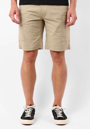 Shorts cargo kaki avec deux poches latérales, fabriqués en matériau en mélange de coton. Présentent une coupe droite et un ourlet cousu. Portés avec des baskets noires.