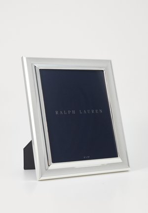 Rechteckiger silberner Bilderrahmen mit spiegelndem Finish, der einen navy-blauen Hintergrund zeigt. Verfügt über einen Ständer für die Tischpräsentation. Größe: 20 cm x 25 cm.