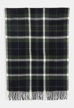 Écharpe rectangulaire en laine avec un motif à carreaux vert foncé, noir et blanc, bordée de franges sur un fond blanc.