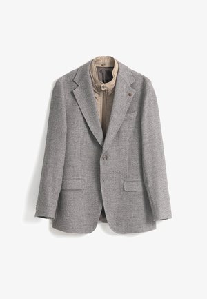 Blazer de grano de café gris con solapas de muesca, cierre de doble botón y una capa interior beige con cremallera. Presenta dos bolsillos frontales y tela texturizada.