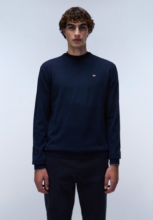 Navyblauwe trui met lange mouwen, ronde hals en geribde manchetten. Heeft een klein rood en wit logo op de linkerkant van de borst.