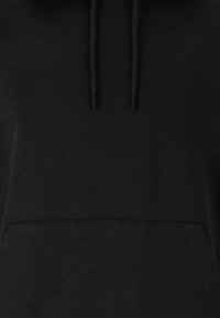 Hoodie noir avec capuche à cordon, tissu texturé, poche kangourou avant et ourlet et poignets côtelés. Design simple et minimaliste.