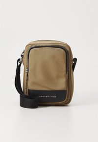 Geantă de umăr din nylon maro cu accente din piele neagră, închidere cu fermoar și curea ajustabilă. Prezintă detalii cu logo și margini cusute.