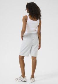 Ljusblå och vita randiga shorts med elastisk midja, sidofickor och uppvikta fållar, tillsammans med en vit linne.