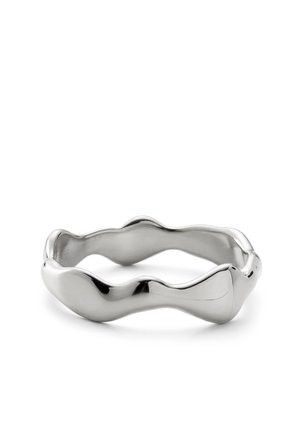 Hopeanvärinen metallisormus, jossa on sileä, epäsäännöllinen aaltoileva muotoilu ja kiillotettu heijastava pinta, esillä valkoisella taustalla.