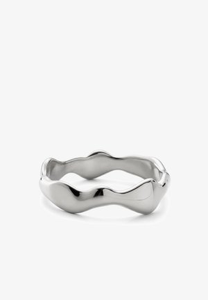 Hopeanvärinen metallisormus, jossa on sileä, epäsäännöllinen aaltoileva muotoilu ja kiillotettu heijastava pinta, esillä valkoisella taustalla.